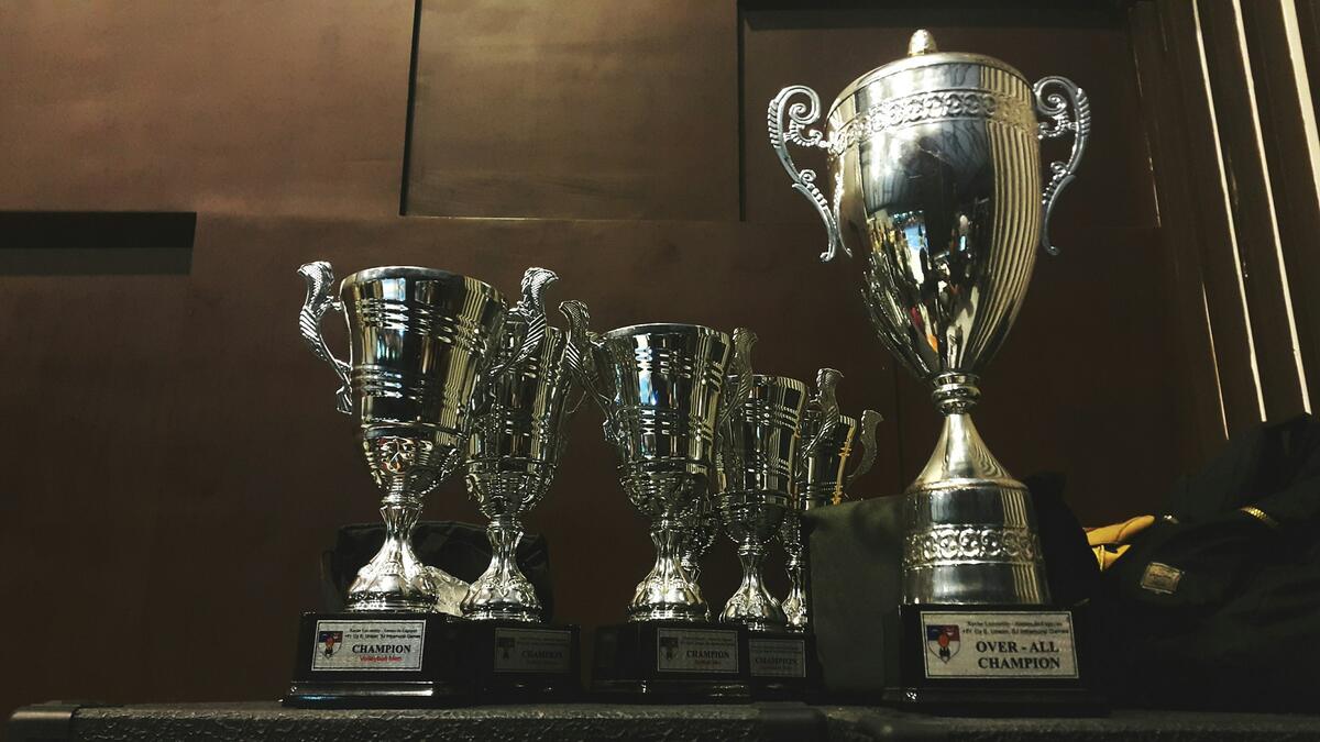 Copas de plata y trofeos clásicos en una vitrina de madera